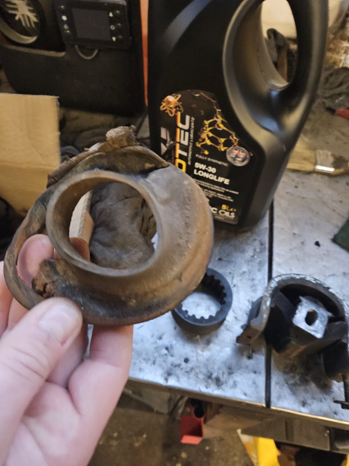 A worn part held up on the workbench